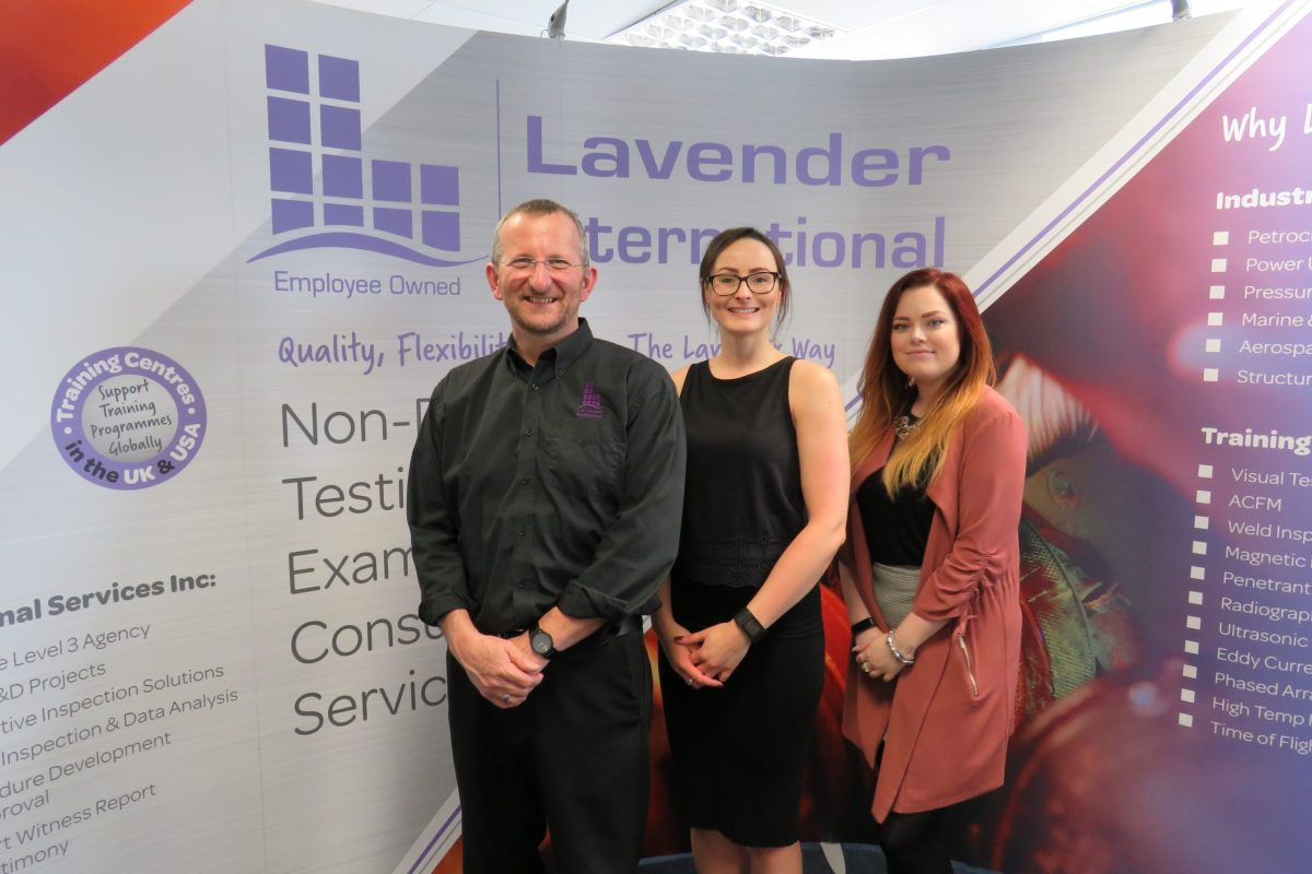 The team at Lavendar International standing in front of their signage