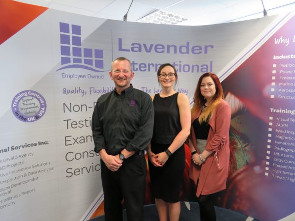 The team at Lavendar International standing in front of their signage